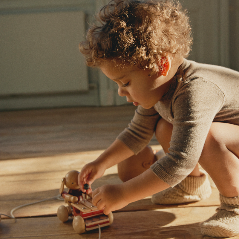 Kind spielt mit Konges Slojd Nachzieh-Hase mit Xylophon aus Holz.