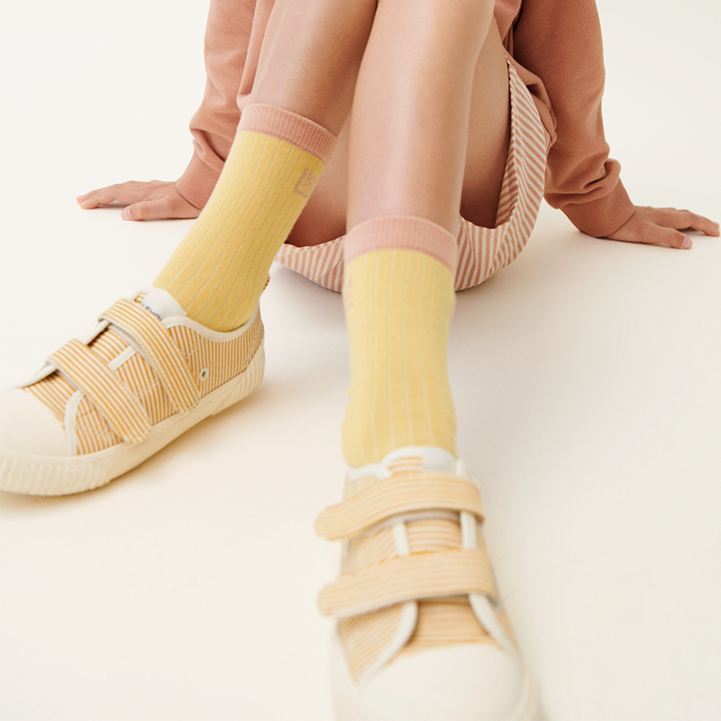 Mädchen trägt ein paar Socken aus dem 3er-Set &#39;Silas&#39; von Liewood in der Farbe Cherry Multi Mix. 
