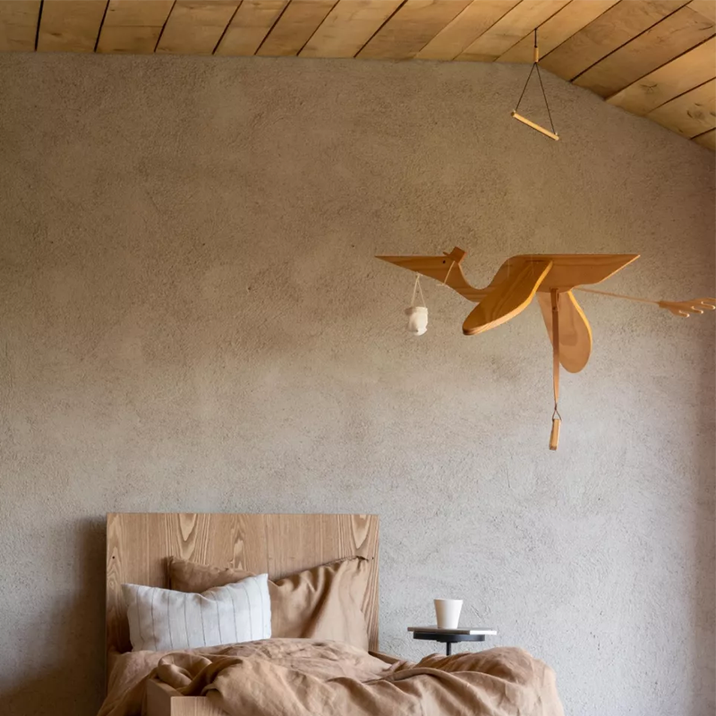Pelikan-Mobile aus Holz fürs Kinderzimmer von Quax hängt über Kinderbett.