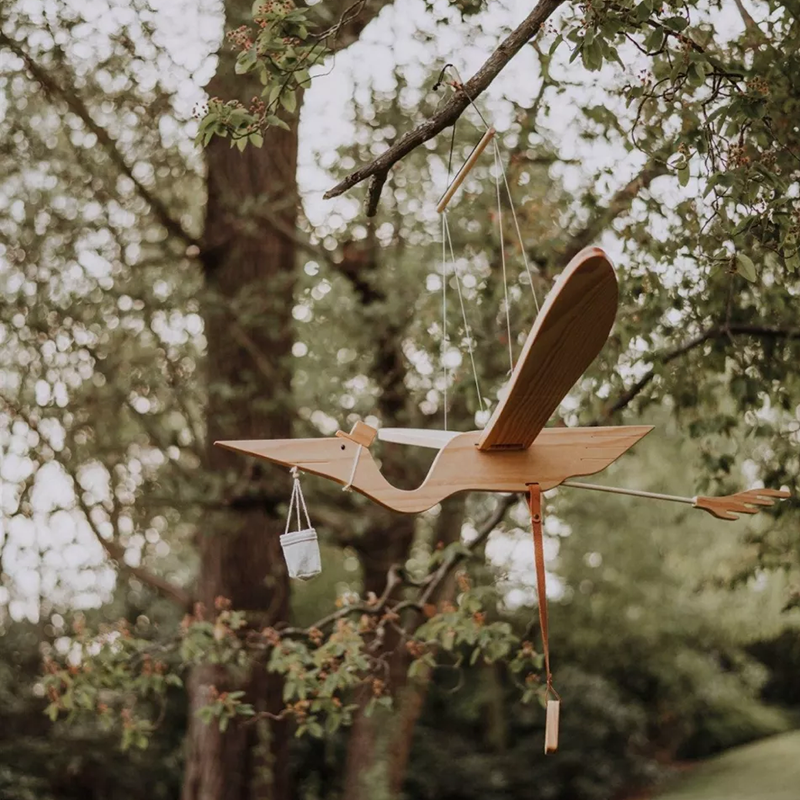 Pelikan-Mobile aus Holz von Quax hängt an Baum.