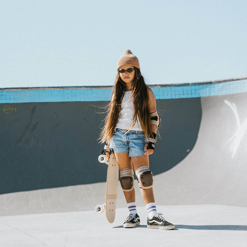 Mädchen mit Banwood Schützausrüstung und Skateboard
