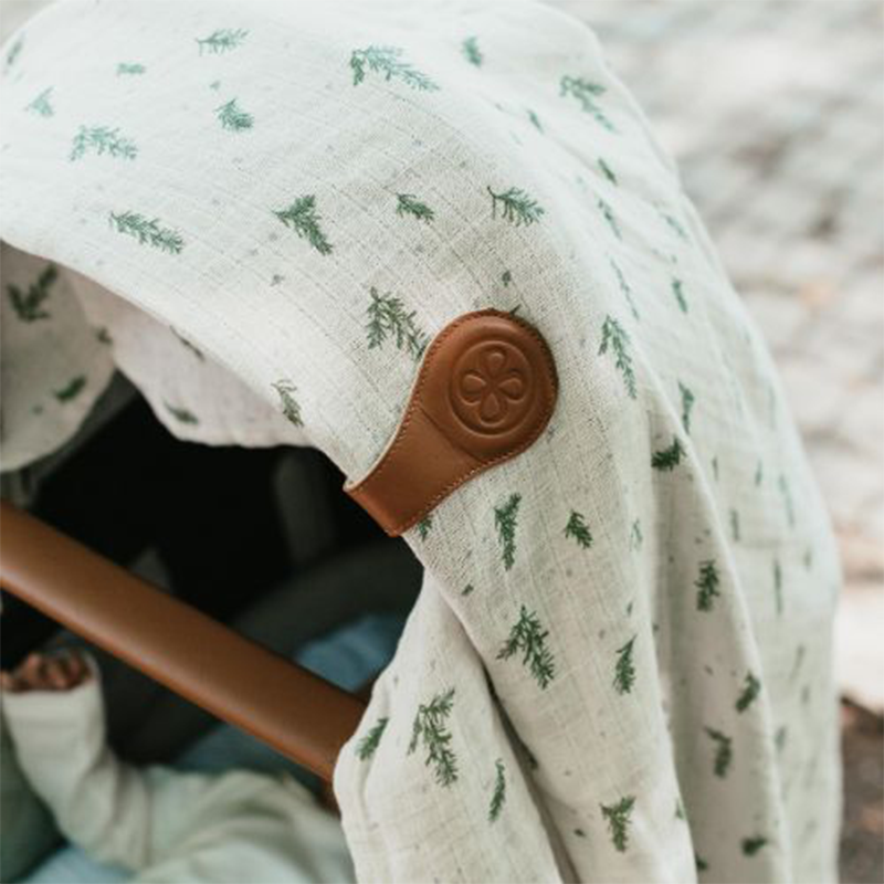 Beiges Tuch befestigt am Kinderwagen mit braunem Magnetclip aus Leder von Cloby.