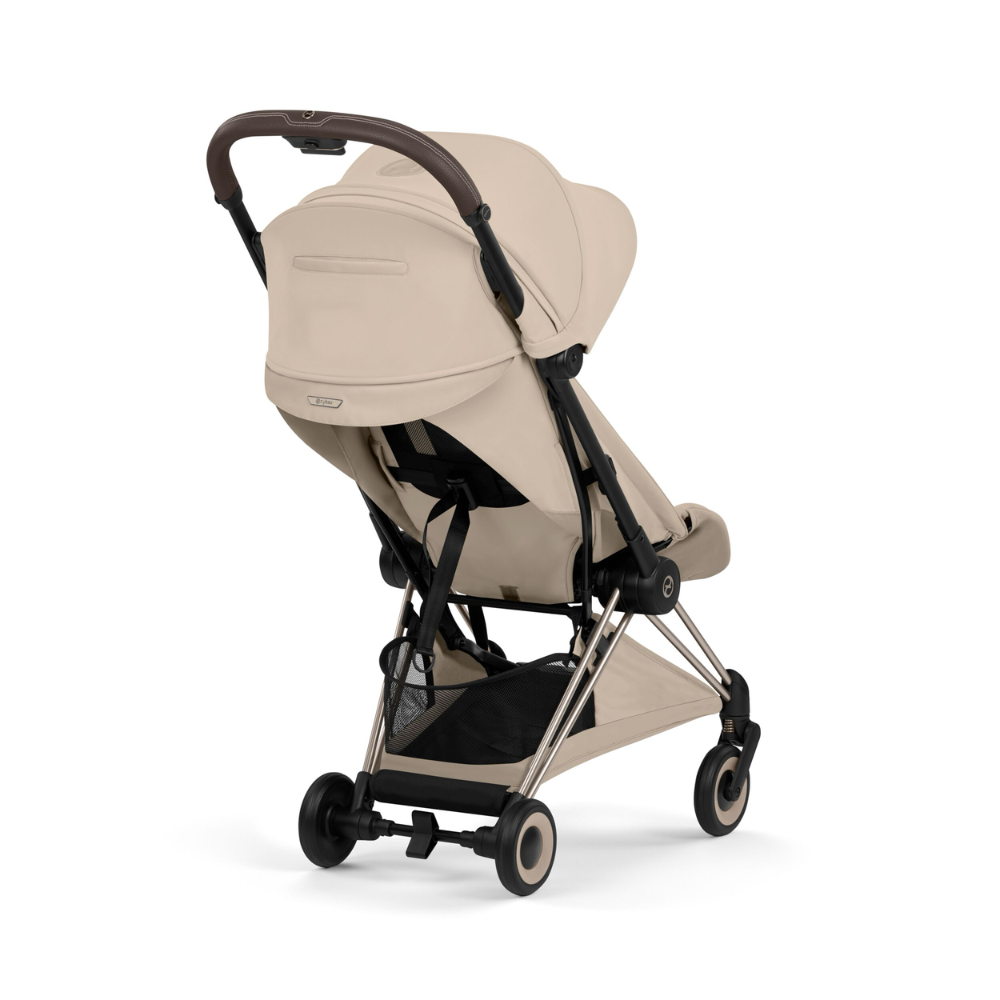 Cybex Coya Buggy in Cozy Beige mit Gestell in Champagne Gold von der Seite von hinten.
