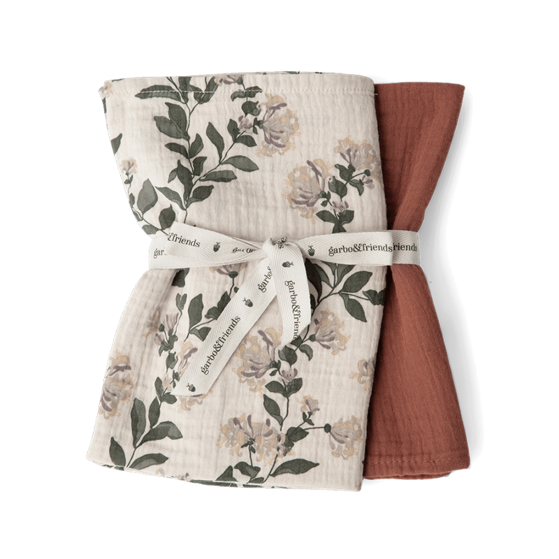 2er Set Mulltücher zusammengefaltet eines in Beige mit Blumen- und Blättermuster und eines in Rot von Garbo and Friends.