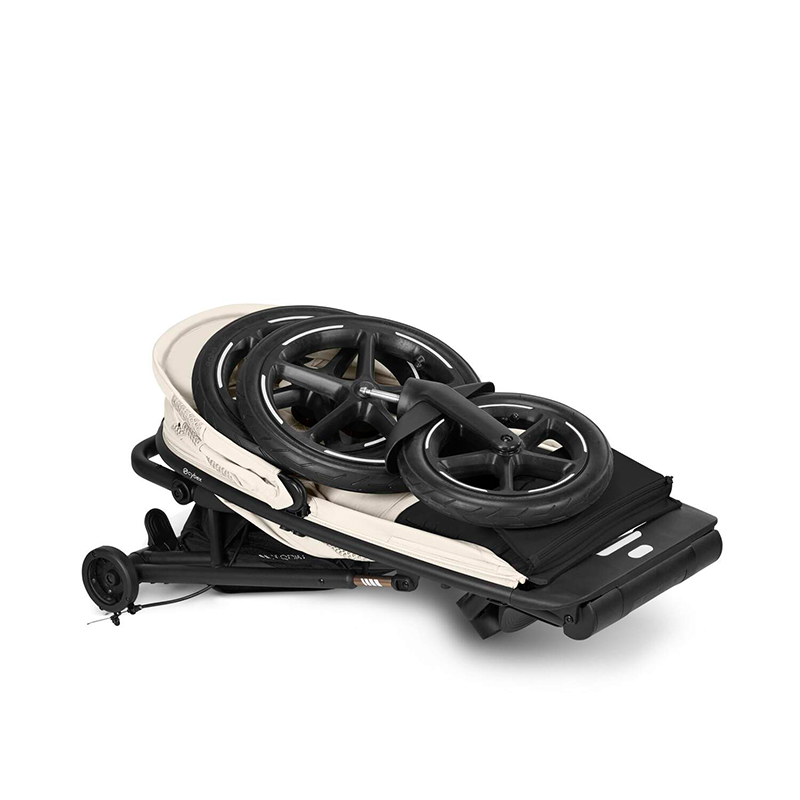 Zusammengefalteter 3-Rad Kinderwagen Avi Spin in Seashell Beige von Cybex. Räder liegen abgenommen auf dem Kinderwagen. 