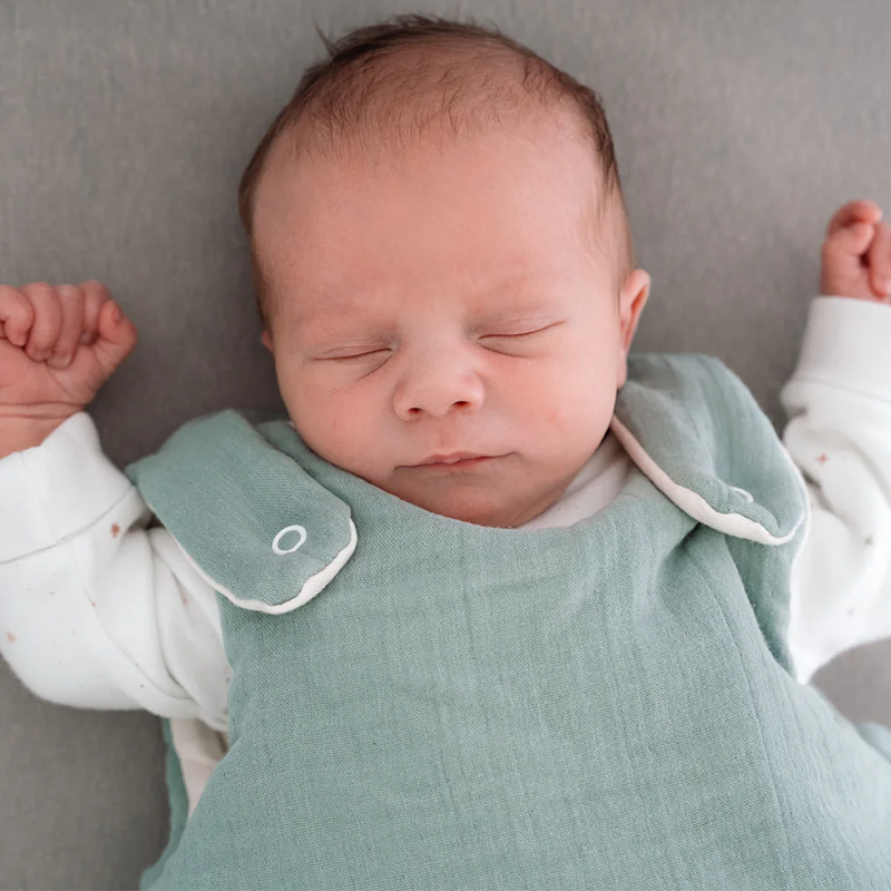 Baby trägt den Julius Zöllner Babyschlafsack in Grün. 