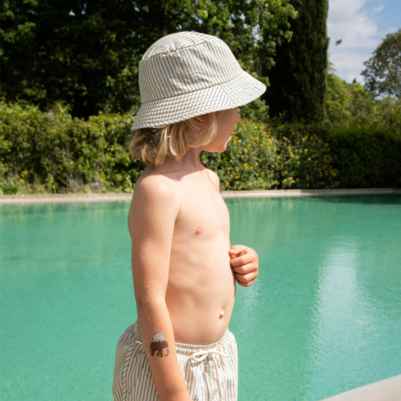 Junge trägt Konges Slojd UV-Sonnenhut mit blauen Streifen