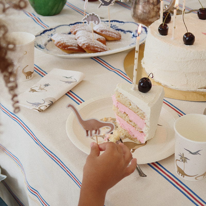 Kinderhand greift nach Tortenstück mit Geburtstagskerzen mit Zitronenmuster von Konges Slojd.