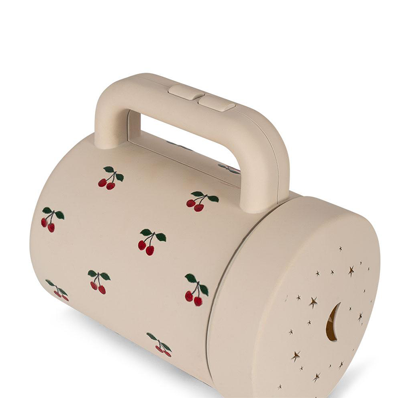 Projektortaschenlampe in Beige mit Aufsatz, um Sternen- und Mondmotive an die Wand zu projizieren von Konges Slojd. 