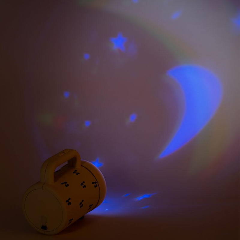 Projektortaschenlampe von Konges Slojd projiziert Sternen und Mond in Blau an die Wand. 