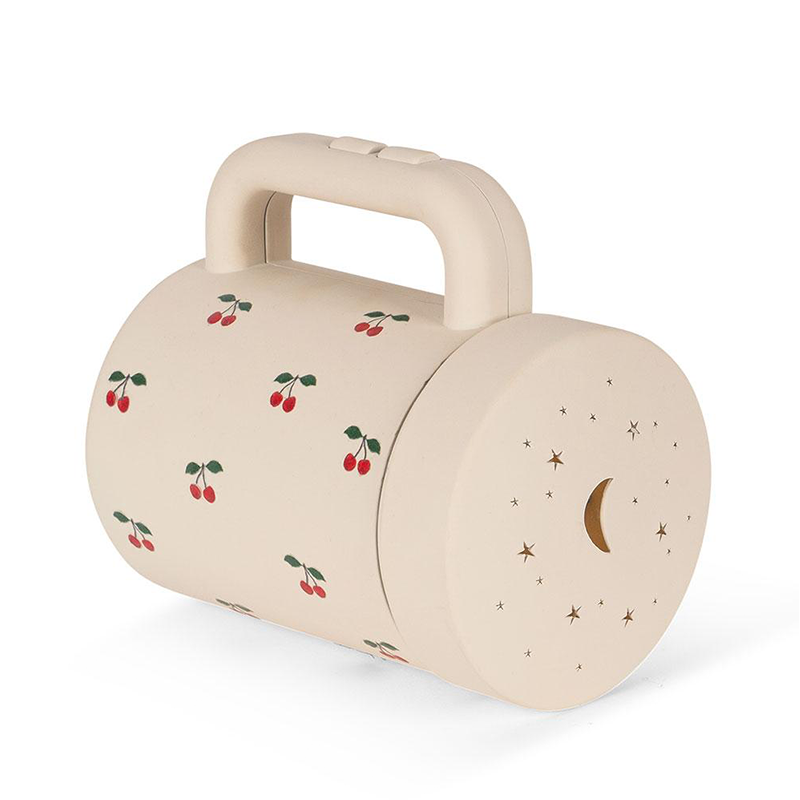 Projektortaschenlampe in Beige mit Aufsatz, um Sternen- und Mondmotive an die Wand zu projizieren von Konges Slojd. 