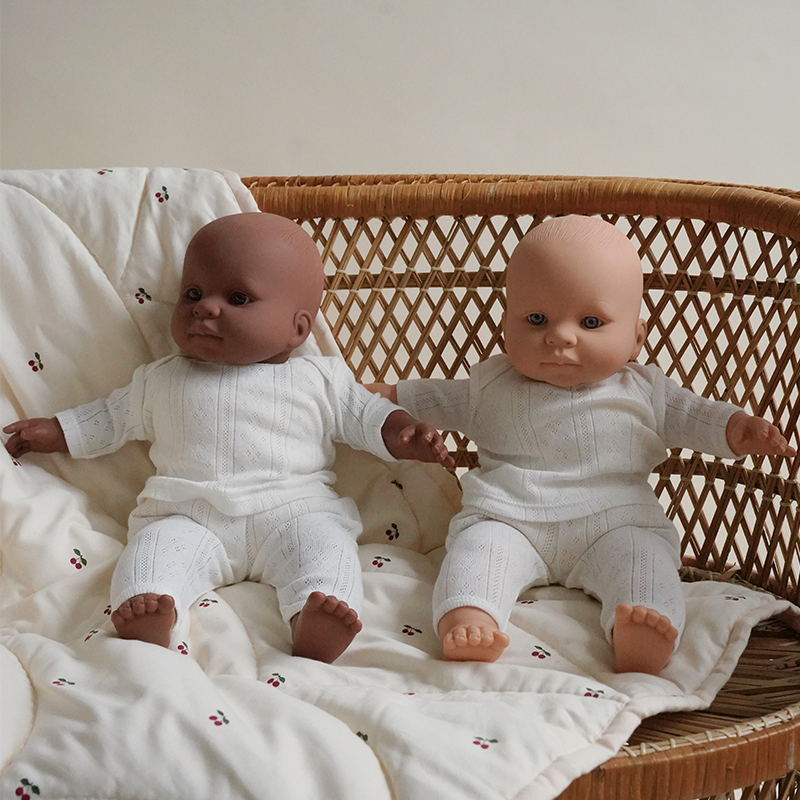 2 Puppen mit weissen Pyjamas von auf einem Stuhl