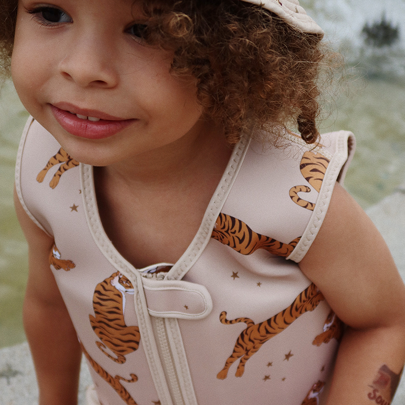 Kind trägt Schwimmweste für Kinder in Beige mit Tiger-und Sternenprint von Konges Slojd.