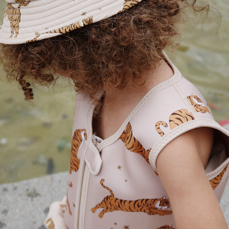 Kind trägt Schwimmweste für Kinder in Beige mit Tiger-und Sternenprint von Konges Slojd.