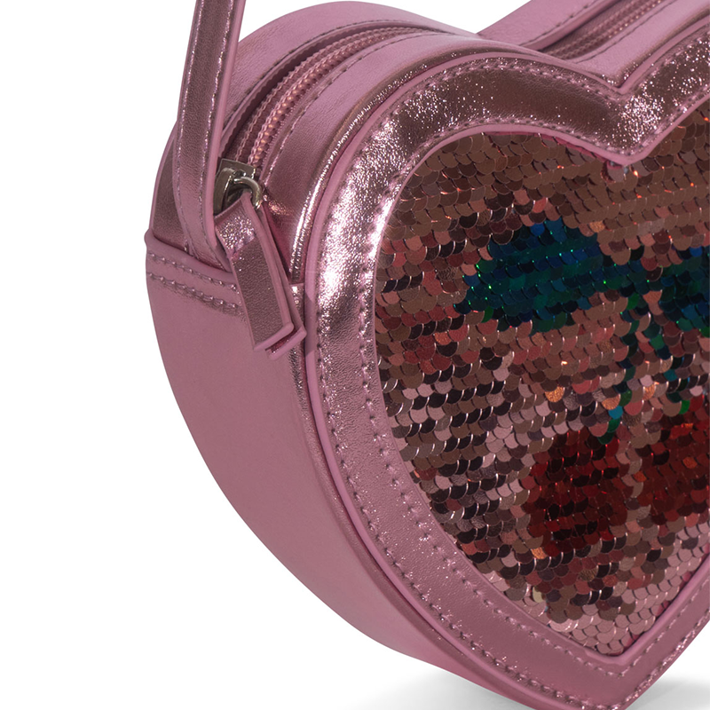Nahaufnahme von der Seite von der Umhängetasche in Herzform mit Pailletten in Rosa von Konges Slojd. 