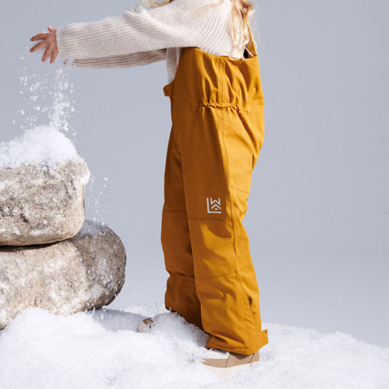 Kind im Schnee mit Schneehose in Golden Caramel von Liewood
