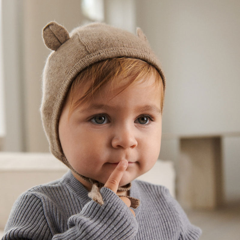 Baby trägt die süsse Kaschmir-Babymütze &quot;Amir&quot; von Liewood – aus feinem hellbraunen Strick mit tollen Öhrchen-Details