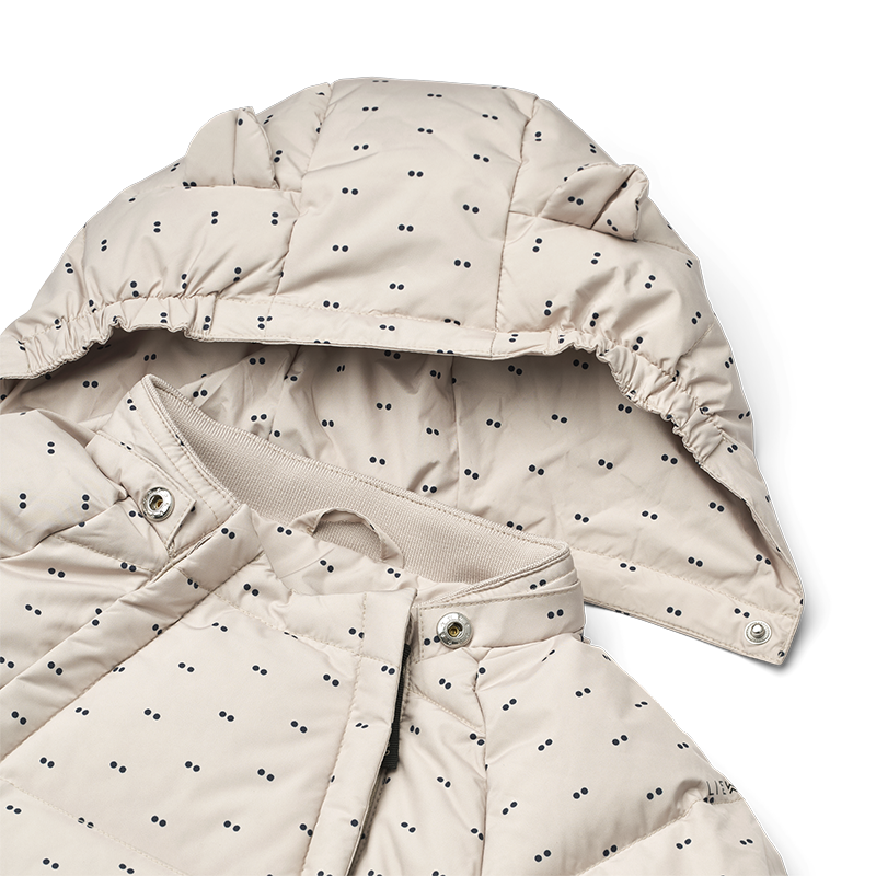 Daunen Schneeanzug in Beige für Babys mit zarten blauen Punkten von Liewood. Nahaufnahme von der Kapuze.