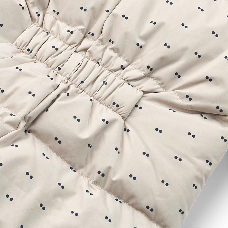 Daunen Schneeanzug in Beige für Babys mit zarten blauen Punkten von Liewood.  Nahaufnahme vom Rücken.