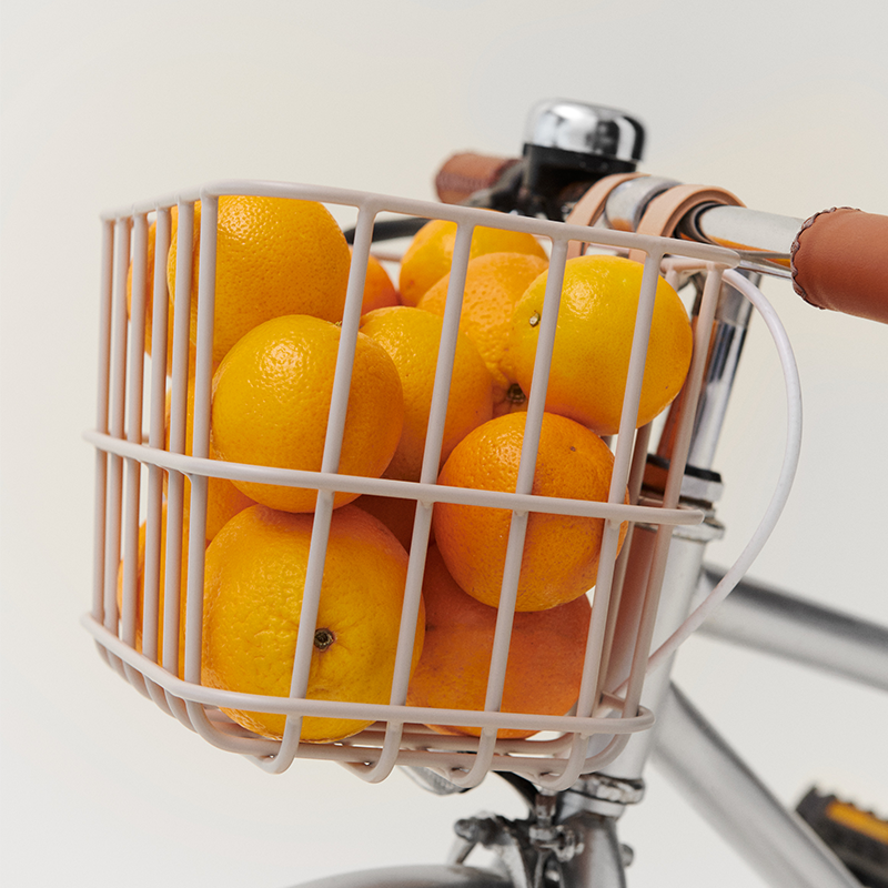 Liewood Fahrradkorb gefüllt mit Orangen an einem Kinderfahrrad. 