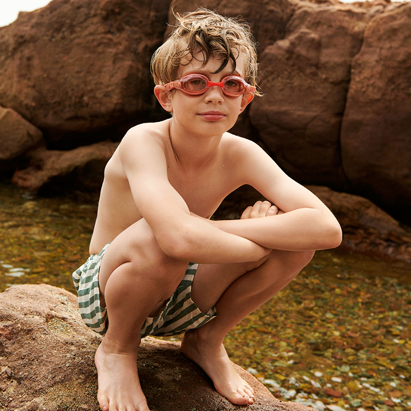 Junge trägt die Liewood Schwimmbrille Titas in Rosa.