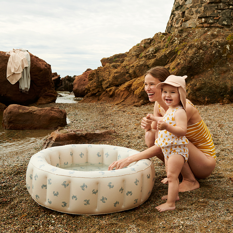 Mädchen spielt mit Mama am Strand und trägt den Liewood Sonnenhut &#39;Senia&#39;. 