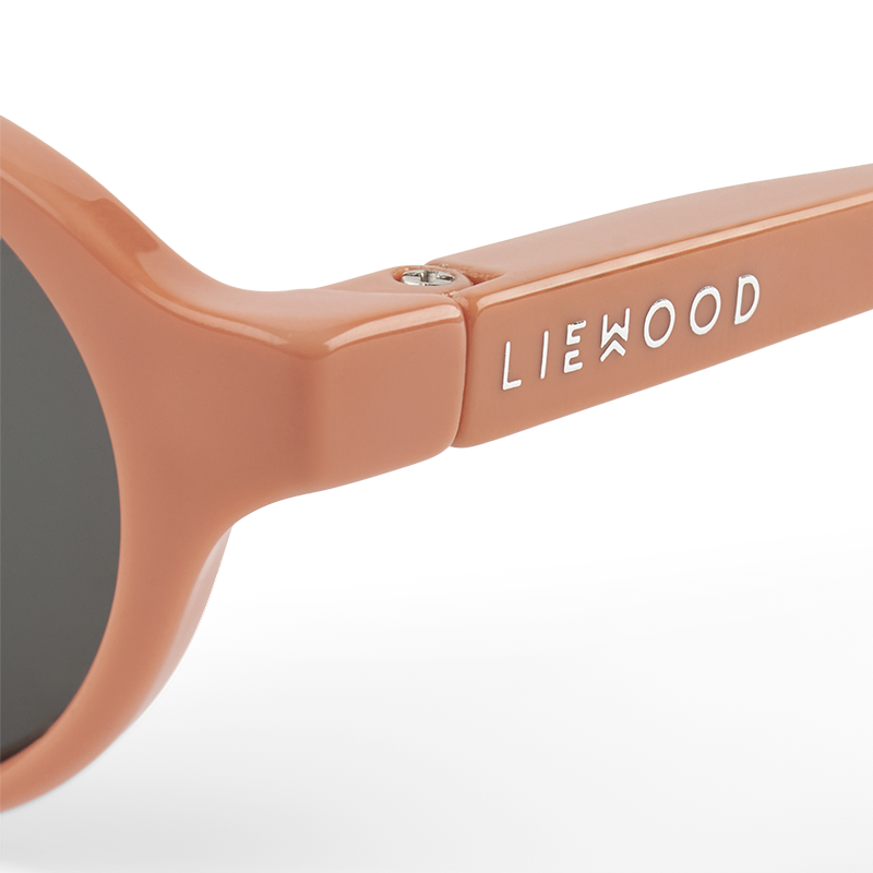 Silberne Liewood Aufschrift von Babysonnenbrille mit rosa Rahmen und rosa Silikonband von Liewood. 