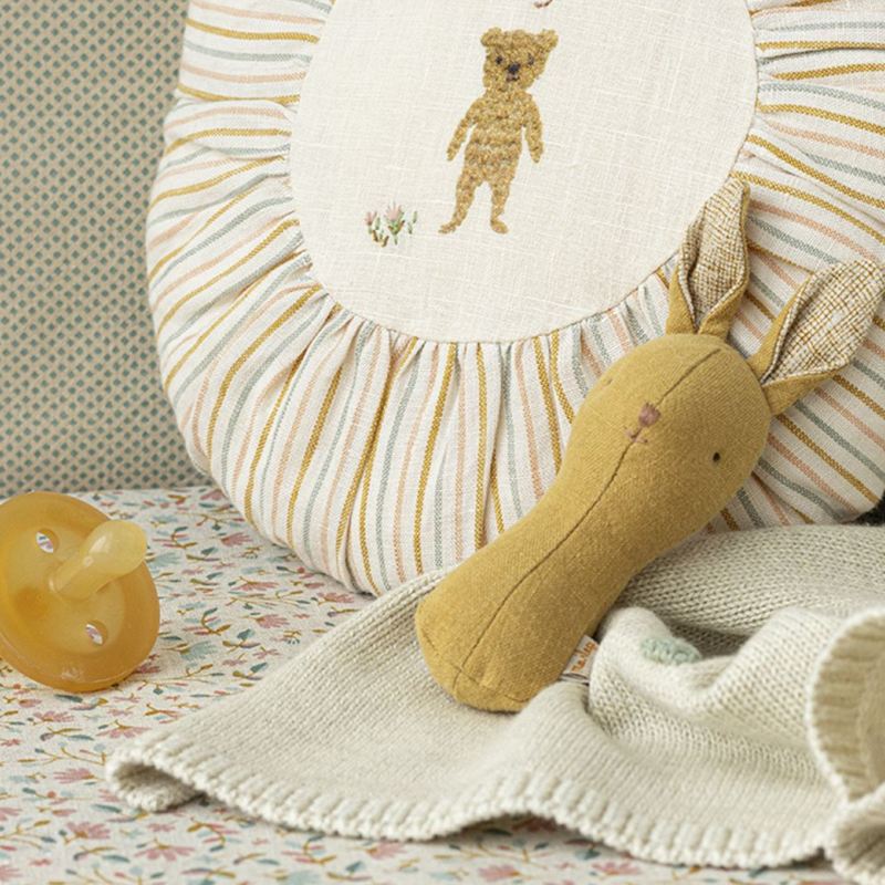 Hasenrassel für Babys in Gelb aus Leinen von Maileg neben einem Schnuller.