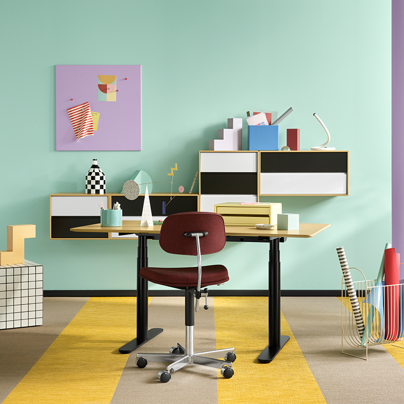 Magnettafel in lila mit passenden Magneten von Montana hängt über Schreibtisch an einer mintfarbenen Wand. 