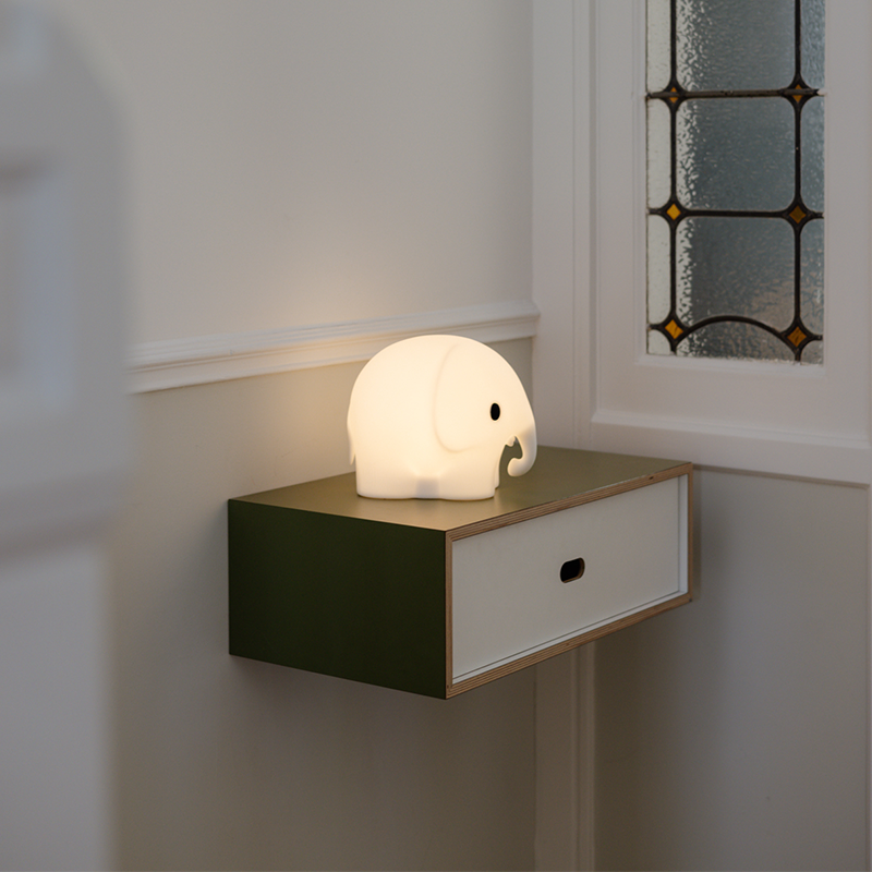 Mr Maria Mini LED-Lampe in Form eines kleinen Elefanten angezündet auf einer Ablage.