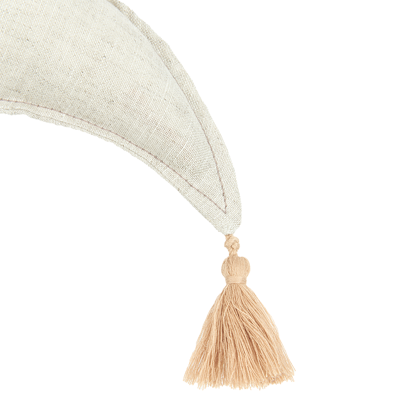 Nahaufnahme vom Bommel vom Nobodinoz Mondkissen in Beige mit Bommel und abgestepptem Rand.