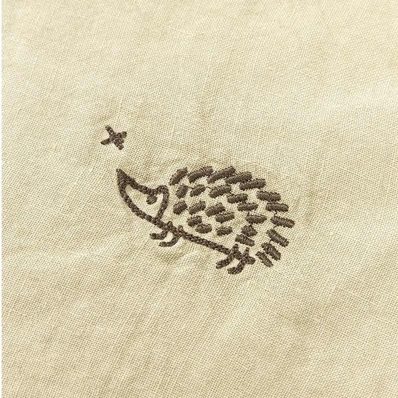 Nahaufnahme von Stickerei von Kuscheldecke in Hellgrün mit Igelstickerei in der Ecke von Nobodinoz.