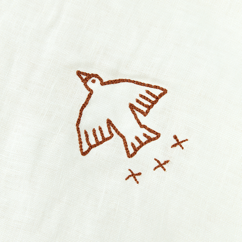 Nahaufnahme von der Vogelstickerei von der weissen Winterdecke von Nobodinoz. 