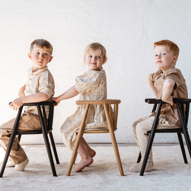 3 Kinder sitzen auf Oaklings &#39;STORM&#39; Kinderstühlen in Oak und Smoked Oak. 