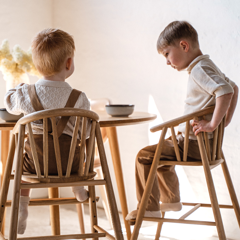 2 Kinder sitzen am Tisch auf dem Oaklings Hochstuhl &#39;SAGA&#39; Oak. 