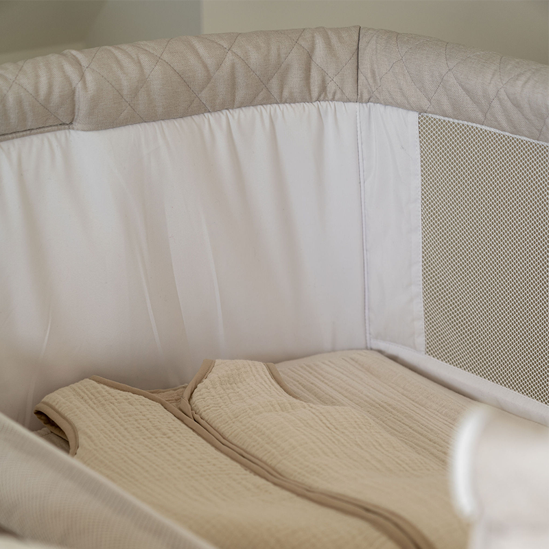 Beistellbett für Babys von oben. Im Bestellbett liegt ein Baby Schlafsack von Quax. 