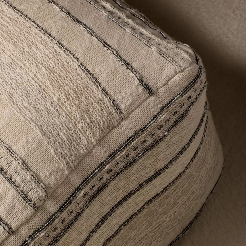 Pouf in Beige mit feinem schwarzen Strickmuster von Quax. Nahaufnahme von der Ecke.