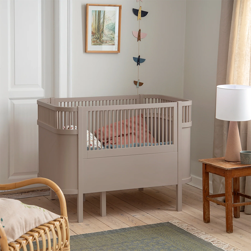 Sebra Baby- und Juniorbett in Beige steht in einem Kinderzimmer.