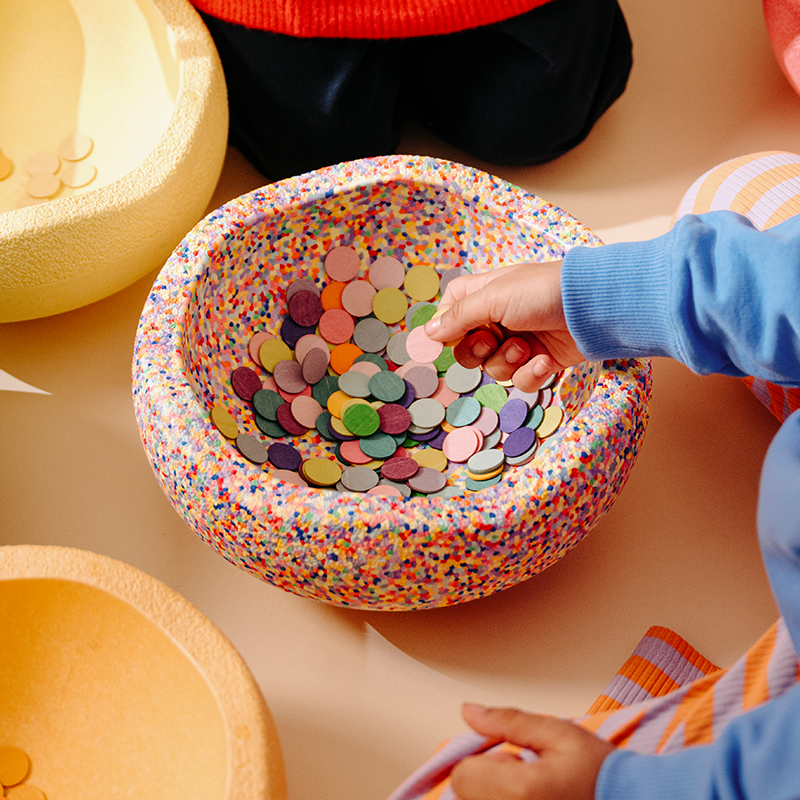 Kinderhand spielt mit dem Stapelstein Super Confetti 