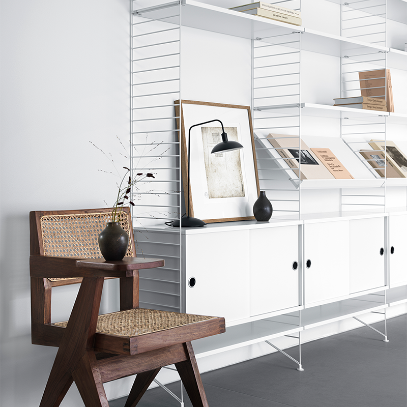 Regalsystem von String Furnitures in Weiss mit Schrankelementen, Zeitschriftenablage und Regalböden. 