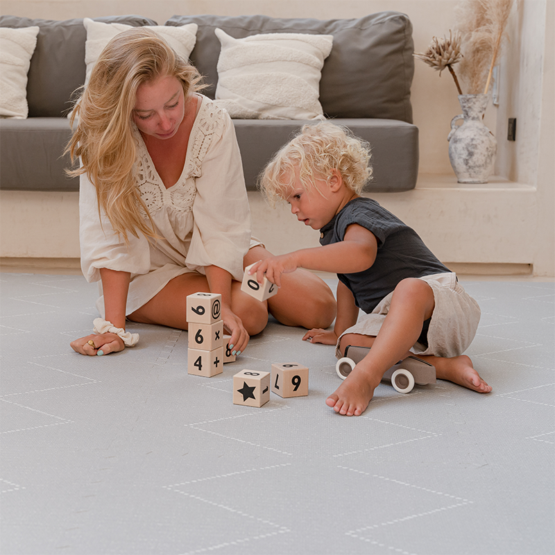 Mama und Junge auf der Toddlekind Spielmatte Tulum. 