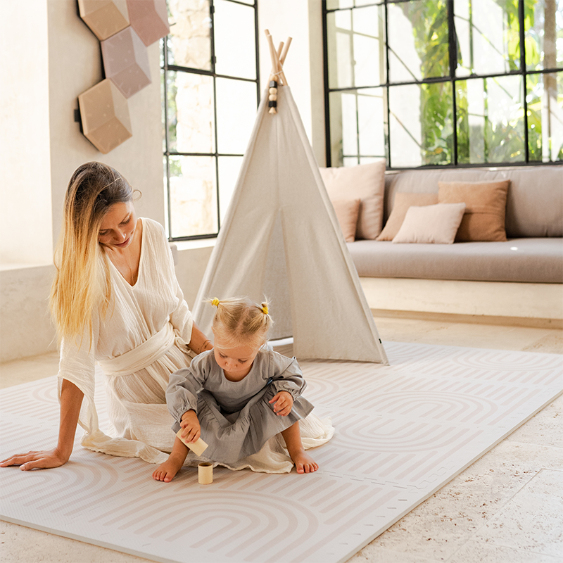 Mama und Tocher spielen gemeinsam auf der Toddlekind Spielmatte Linear in der Farbe Linen. 