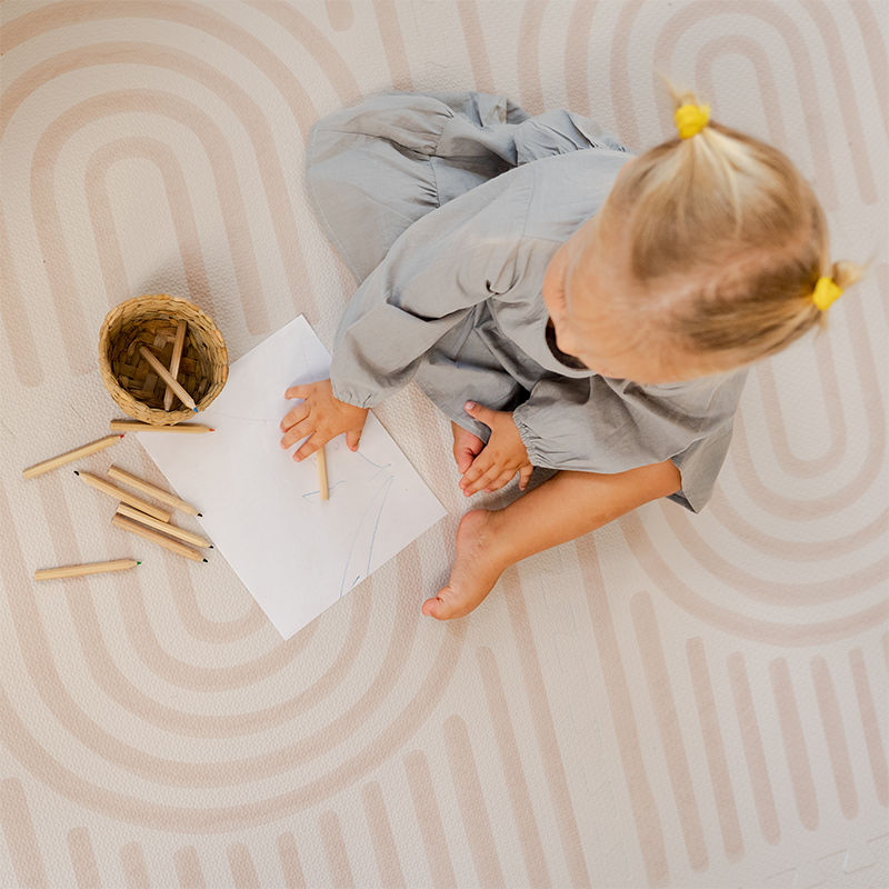 Kind spielt auf der Toddlekind Puzzlematte Linear in der Farbe Linen .